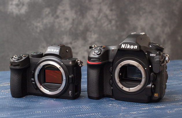 A mirrorless camera and a DSLR side by side with their lenses removed, showing the sensor of one and the mirror of the other