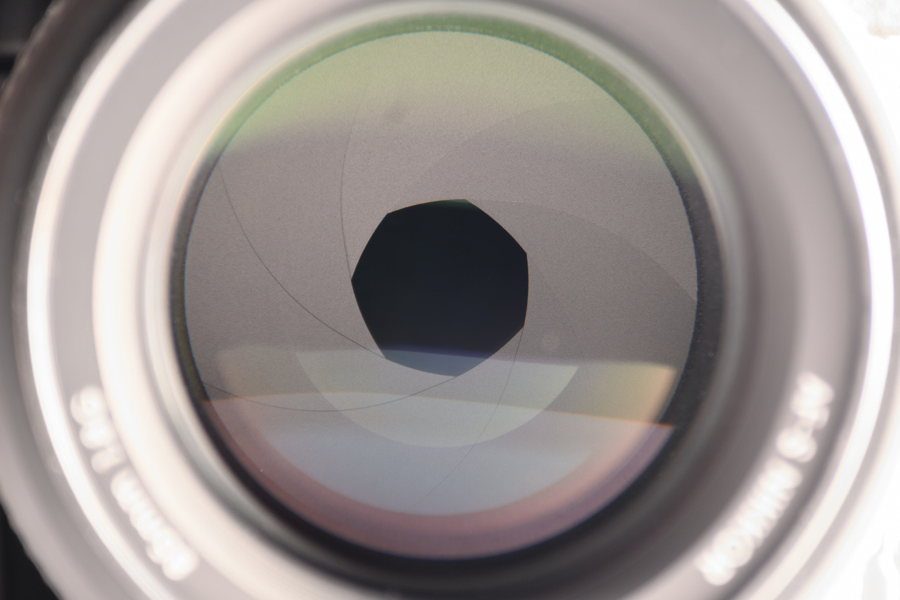 Close-up of aperture blades inside a lens forming a nine-sided opening